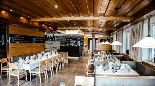 a dining room with white tables and chairs at Landhotel Atzmüller in Waxenberg