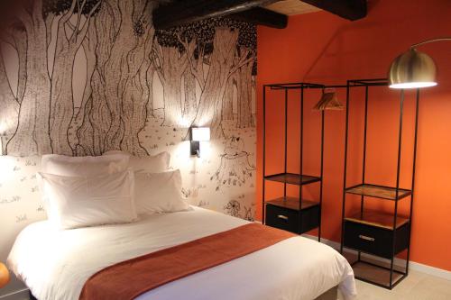 a bedroom with a bed with an orange wall at Les Gîtes de la Billebaude - Gîte du Renard in Eckwersheim