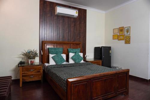 a bedroom with a wooden bed with green pillows at Perch Arbor Suites in Gurgaon