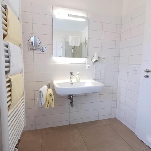 a white bathroom with a sink and a mirror at Hölbinger Alm - Apartments in Anger