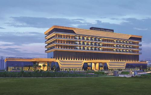 a large building with a lawn in front of it at Gift City Club, a member of Radisson Individuals in Gandhinagar