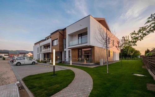 una macchina bianca parcheggiata di fronte a un edificio di Uno Retreat Residence a Braşov