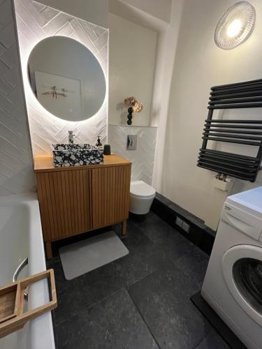 une salle de bain avec un lavabo, des toilettes et un miroir dans l'établissement Essence des Carmes - T3 en hyper centre et climatisé, à Toulouse