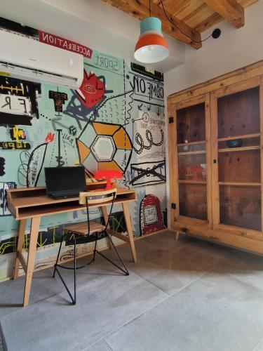 a room with a desk and a wall with graffiti at La belle grange in Arnave