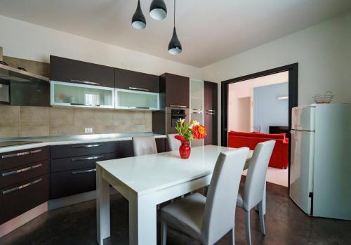 cocina con mesa blanca, sillas y nevera en Guest Friends, en Trapani