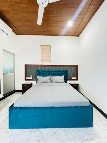 a bedroom with a blue bed in a room at Millennium Luxury Apartments in Negombo