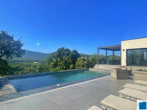 une piscine devant une maison dans l'établissement Architect's Villa - 10-12 people - Pool - 4 bedrooms, à Zonza