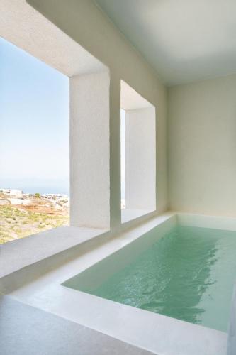 a swimming pool in a room with a view of the ocean at Gazelle Living in Imerovigli