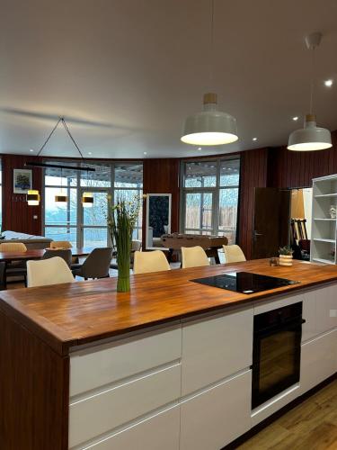 une cuisine avec un comptoir et une salle à manger avec des tables dans l'établissement Location gîte atypique Jura, à Lons-le-Saunier