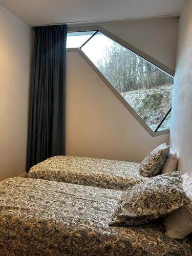 une chambre avec deux lits et une grande fenêtre dans l'établissement Location gîte atypique Jura, à Lons-le-Saunier