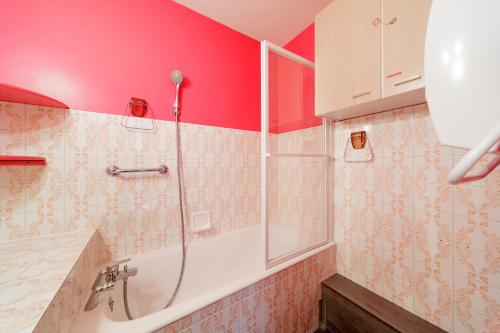 a bathroom with a shower with red walls and a sink at Le Nid de Gourette - Au Pied des Pistes in Eaux-Bonnes