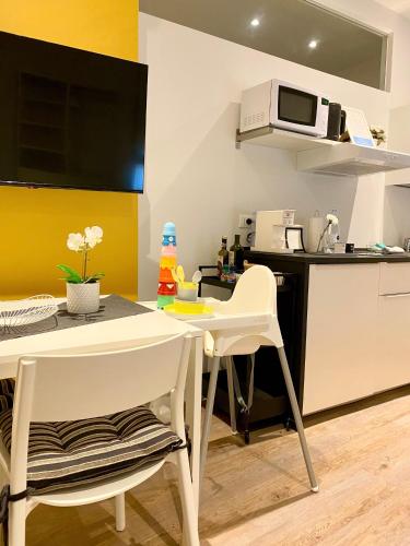 a kitchen with a table and two chairs and a microwave at Suite Apartments - Corso51 in Rimini