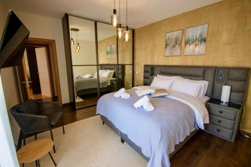 a bedroom with a large bed with towels on it at LUXE COASTAL RETREAT Apartment in Alexandroupoli
