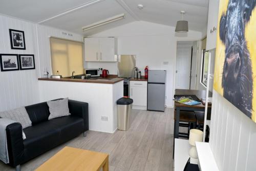 a living room with a couch and a kitchen at Bunnahabhain 5 - Farm Stay - Stunning sea and rural views in Stranraer