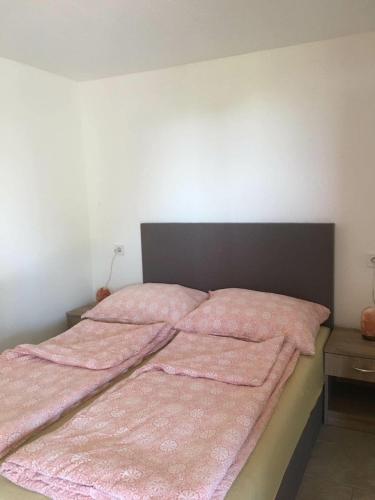 a bed with a pink blanket on top of it at A Fogadó Vendégház in Sárospatak