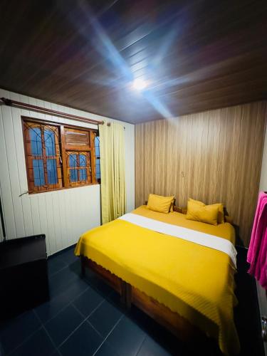a yellow bed in a room with a window at ABC Guest Inn & Restaurant in Haputale