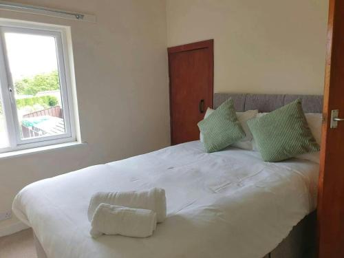 a bedroom with a large white bed with a window at Beautiful House in Stoke in Audley