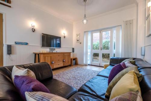 a living room with a couch and a tv at Cosy Nook, Southwold in Southwold