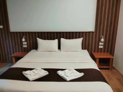 a bedroom with a large bed with two towels on it at Khao Sok Nature Place - SHA Certified in Khao Sok