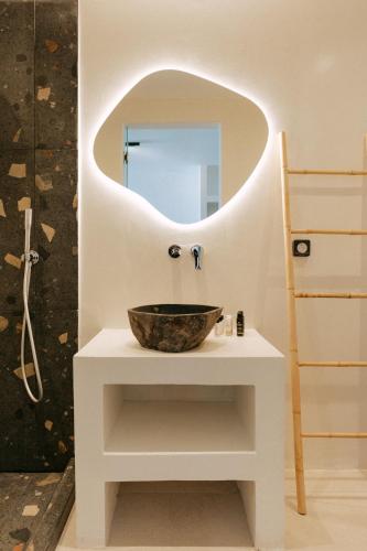 a bathroom with a bowl sink and a mirror at Gazelle Living in Imerovigli