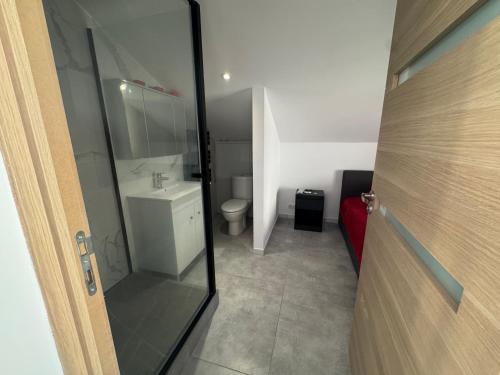 a bathroom with a toilet and a glass door at niolonlabricotier in Le Rove