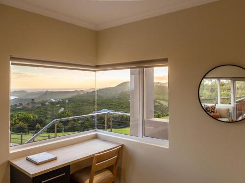 a room with a window with a desk and a mirror at Pincushion Heights in Brenton-on-Sea