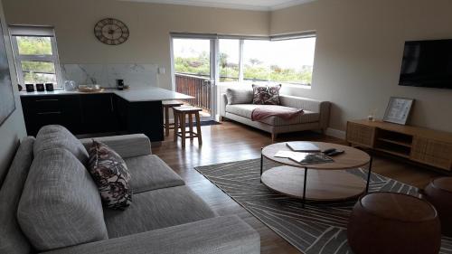 a living room with a couch and a table at Pincushion Heights in Brenton-on-Sea