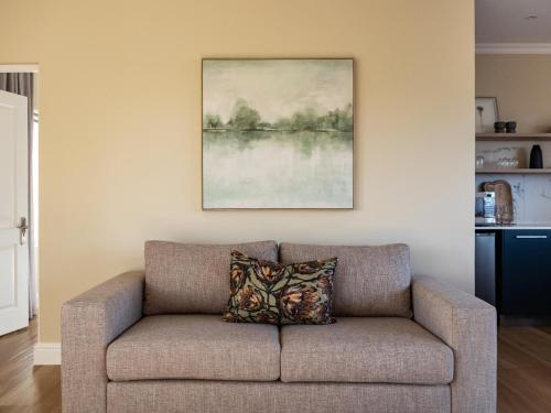 a couch in a living room with a painting on the wall at Pincushion Heights in Brenton-on-Sea