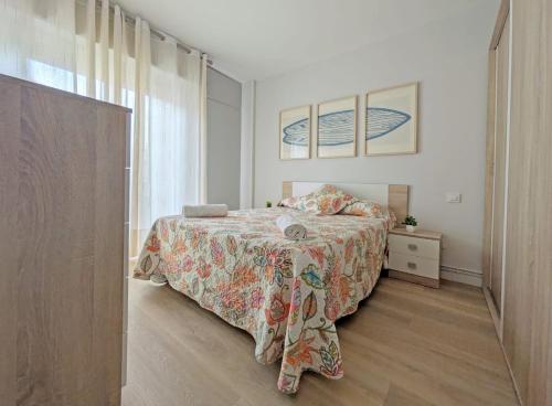 Un dormitorio con una cama y una cómoda y una ventana. en Apartamento en la Playa de Somo., en Somo