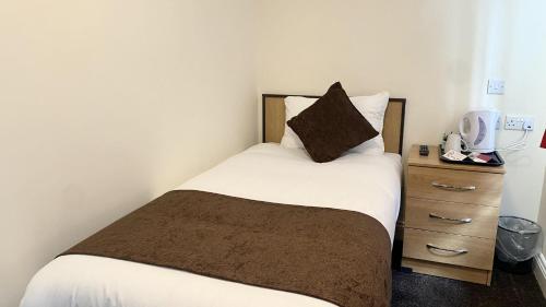 a bedroom with a bed with a pillow and a nightstand at Russ Hill Hotel in Charlwood