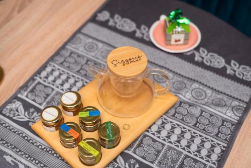a glass jar on a wooden tray with miniature coins at Sizgoric Palace Suites Sibenik in Šibenik