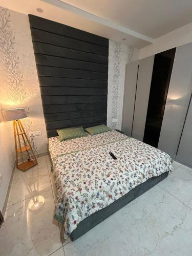 a bedroom with a large bed with a black headboard at Aerogreen Homestays in Zirakpur