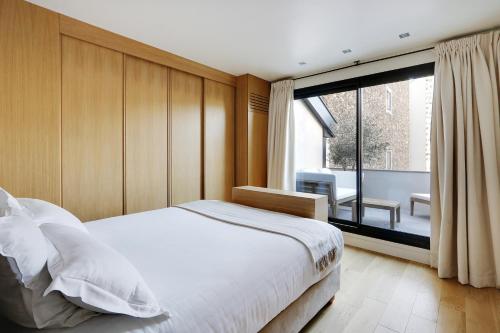 une chambre avec un lit et une grande fenêtre dans l'établissement Pick A Flat's apartment Place Victor Hugo - Rue des Belles Feuilles, à Paris