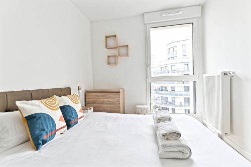 - une chambre blanche avec une grande fenêtre et un lit dans l'établissement Spacieux 3 chambres avec balcon - Colombes, à Colombes