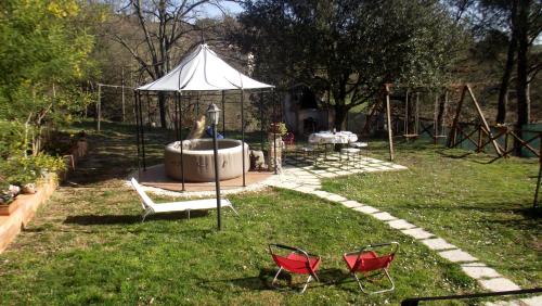 two chairs and an umbrella in a yard at La casetta rossa in Collicello