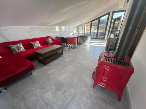 a living room with a red couch and a wood stove at niolonlabricotier in Le Rove