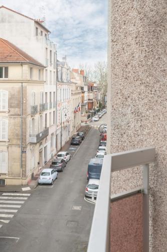 a view of a city street with parked cars at L'Alquié - Appartement design hyper centre in Vichy