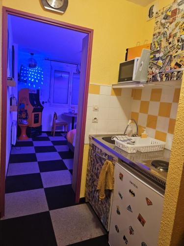 a kitchen with a black and white checkered floor at Insolite Les années 80 ! in Lunéville