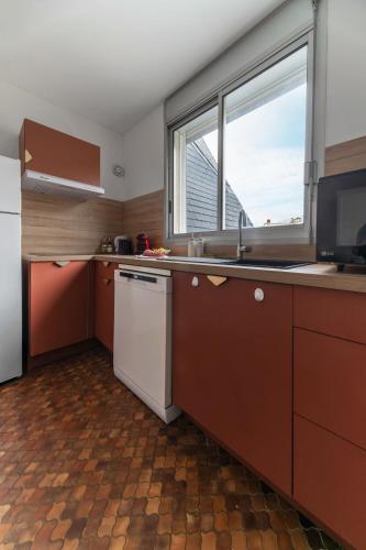 a kitchen with a sink and a large window at L'Alquié - Appartement design hyper centre in Vichy