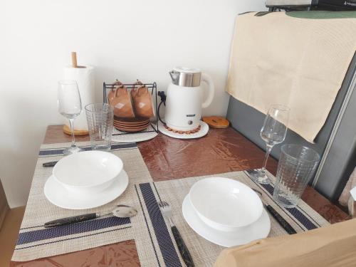 a table with white plates and glasses on it at Janna's Condo in Mactan in Lapu Lapu City