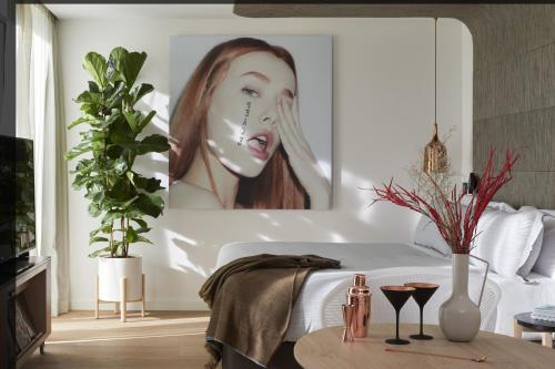 a bedroom with a picture of a woman on the wall at ME Barcelona in Barcelona