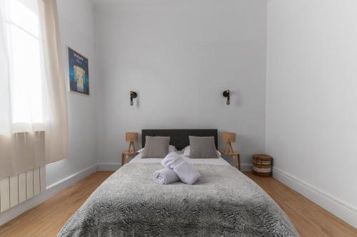 une chambre avec un lit avec un animal en peluche dessus dans l'établissement Le Larbaud - Appartement calme en centre ville, à Vichy