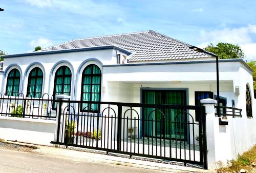 a white house with a black fence at Le Trang Boutique Airport in Trang