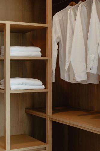 a closet with some white shirts and a shirt at Casa Jasmine H2 l Private Pool 3BR Near Nimman in Chiang Mai
