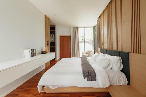 a bedroom with a large white bed with white pillows at Casa Jasmine H2 l Private Pool 3BR Near Nimman in Chiang Mai