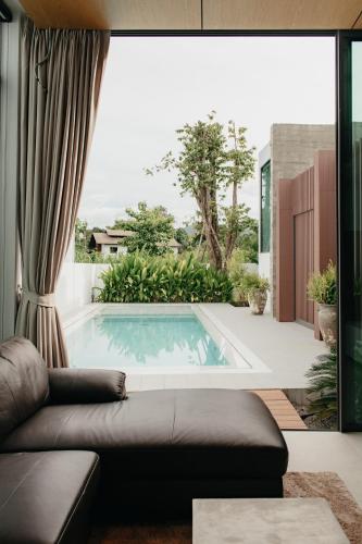 a living room with a pool and a couch at Casa Jasmine H2 l Private Pool 3BR Near Nimman in Chiang Mai