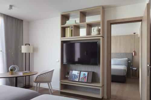 a hotel room with a tv and a bedroom at ME Barcelona in Barcelona