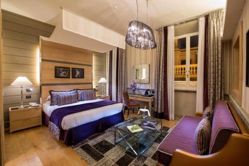 a hotel room with a bed and a couch at The Inn at the Spanish Steps Luxury Collection - The Inn at the Spanish Steps in Rome