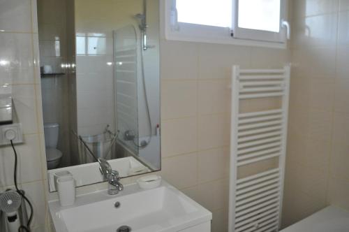 une salle de bain blanche avec un lavabo et un miroir dans l'établissement Villa Ita 6 to 8 berths - Private pool, à Moliets-et-Maa