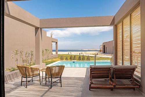 a patio with a table and chairs and a pool at Sentido Naga Bay - Adults friendly in Hurghada